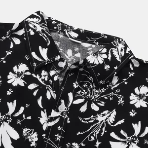 Detailansicht eines schwarz-weißen Hawaiihemds für Herren mit Blumenmuster und Kragen.