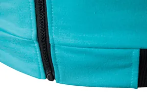 Gros plan sur la fermeture éclair noire et le tissu turquoise respirant du gilet