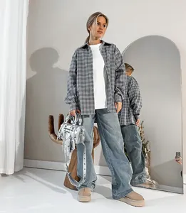 Detail view of women's oversized grey plaid shirt with a stylish turn-down collar