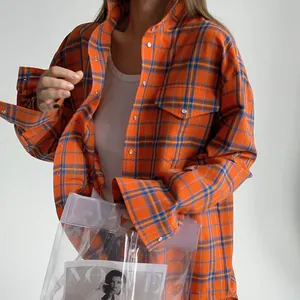 Dettaglio di una camicia a quadri arancione e blu in stile college americano da donna