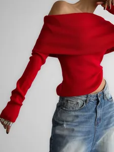 Detail shot of a bright red off-shoulder long sleeve knitted top with rib texture.