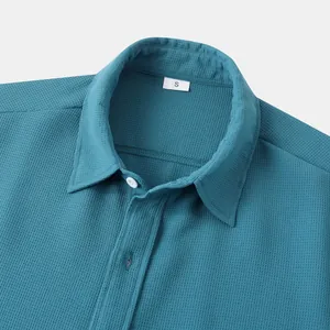 Close-up view of a men's blue short sleeve casual shirt collar with waffle knit texture detail