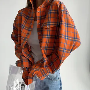 Modella che indossa un'elegante camicia a quadri arancione ampia con maniche lunghe