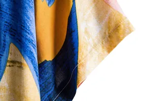 Macro detail of colorful floral print fabric and stitching on a men's summer shirt.
