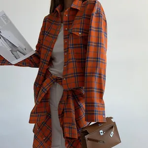 Dettaglio della camicia a quadretti arancione oversize con colletto a rever e tasca