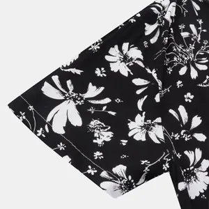 Detailaufnahme des schwarz-weißen Blumendrucks auf einem Herren-Hawaiihemd mit Kurzarm