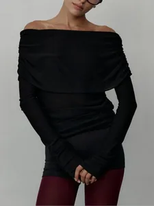 Detail of a women's black off-the-shoulder knit top featuring a draped neckline and slim fit