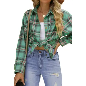 Dettaglio di una camicia a quadri verde e nera annodata in vita per un look casual