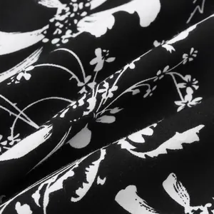 Makroaufnahme von schwarz-weißem Blumenmuster auf der Stofftextur eines Hawaiihemdes