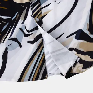 Gros plan montrant le motif floral hawaïen détaillé et le bouton d'une chemise pour hommes.