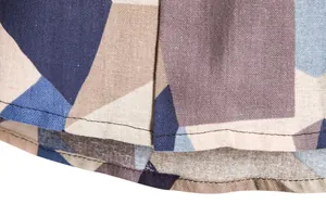 Detailed close-up of geometric print fabric and double-stitched hem on men's casual shirt.