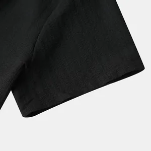 Close-up detail showing the crinkled seersucker fabric texture of a black shirt sleeve