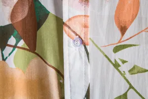 Detailed macro view showing the clear button and floral pattern on a men's summer shirt.