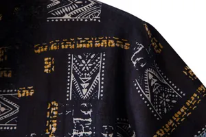 Close-up of ethnic geometric print and fabric texture on a black men's beach shirt.