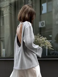 Détail d'un pull en maille gris dos nu avec une coupe en U sexy et une coupe décontractée.