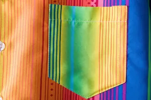 Close-up detail of the vibrant colorful ethnic striped pocket on a men's Hawaiian shirt.
