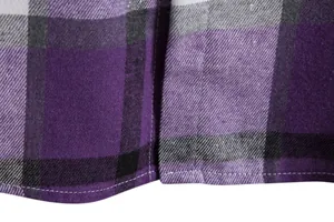 Macro che mostra la trama del tessuto e le cuciture dell'orlo di una camicia viola.