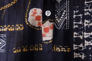 Close-up of the button and ethnic printed fabric on a men's beach holiday shirt.
