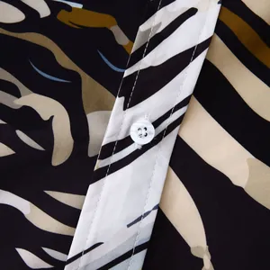 Gros plan détaillé du bouton blanc et du motif floral d'une chemise hawaïenne pour hommes