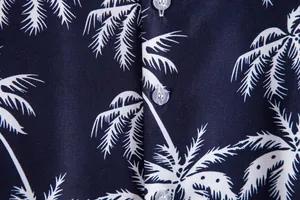 Detalle macro de camisa casual azul marino para hombre con estampado de palmeras y botones