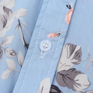 Makrodetail eines blauen Herren-Hawaiihemdes mit Blumenmuster, Knopf und Stofftextur.