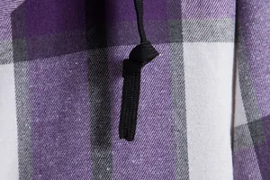 Dettaglio ravvicinato del tessuto della camicia a quadri viola e neri con cordino