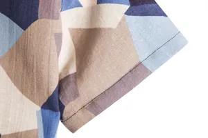Macro detail of geometric pattern and fine stitching on men's retro Hawaiian cotton shirt