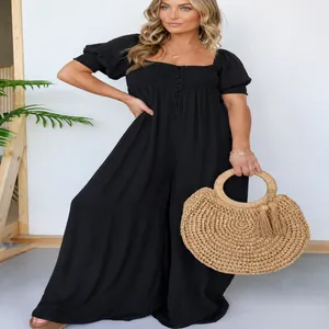 Modell trägt einen schicken schwarzen Jumpsuit in Übergröße mit Puffärmeln und weitem Bein