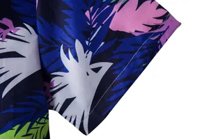 Close-up view of the detailed tropical palm leaf print on a men's Hawaiian short sleeve shirt