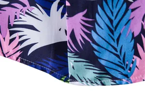 Detailed close-up of the curved hem and vibrant tropical leaf print on a men's Hawaiian shirt.
