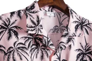 Detalle de camisa rosa de manga corta para hombre con palmeras negras