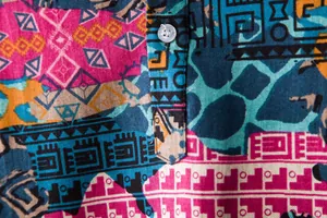 Macro detail of men's short sleeve shirt with vibrant ethnic tribal geometric print.