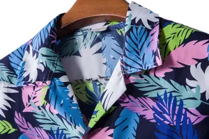 Close-up detail of vibrant tropical leaf print on men's Hawaiian short sleeve shirt collar.