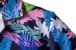 Close-up detail of vibrant tropical leaf print on men's Hawaiian short sleeve shirt