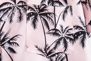 Primer plano de una camisa rosa de hombre con estampado de palmeras negras y bolsillo