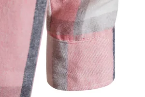 Dettaglio del polsino di una camicia a quadri rosa e bianca con cuciture e trama del tessuto.