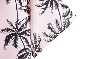 Primer plano del detalle de la manga de una camisa rosa de hombre con palmeras
