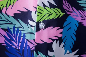 Macro view of colorful tropical leaf pattern and clear button on Hawaiian shirt