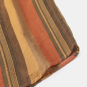 Close-up of vertical striped fabric and hem stitching on men's Hawaiian shirt.