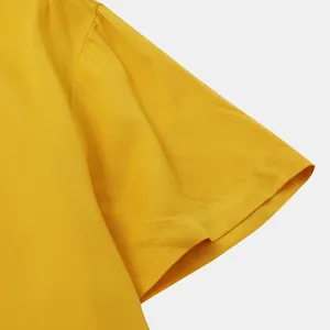 Detailed view of yellow cotton fabric and sleeve stitching on casual men's shirt