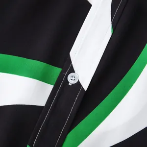 Gros plan d'un bouton et d'un tissu à rayures vertes sur une chemise hawaïenne