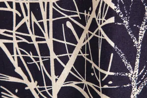 Detailed macro shot showing the vintage tree branch print texture of a Hawaiian casual shirt