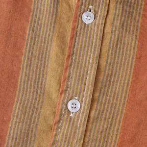 Macro view of men's summer Hawaiian shirt showing orange striped linen fabric and buttons