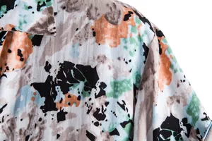Close-up of men's casual shirt featuring abstract splatter paint print and soft fabric.