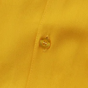 Macro detail of yellow men's casual shirt showing fabric texture and button