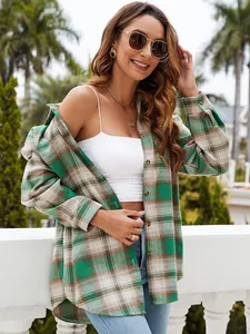 Women's green plaid long sleeve button-down shirt over white tank top in outdoor setting