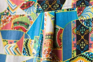 Macro detail of vibrant bohemian print on men's casual linen shirt fabric material