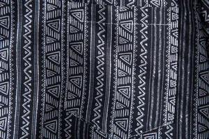 Macro detail of black and white ethnic geometric pattern on men's Hawaiian shirt fabric
