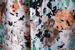 Macro view of the front button placket on a men's casual floral print summer shirt