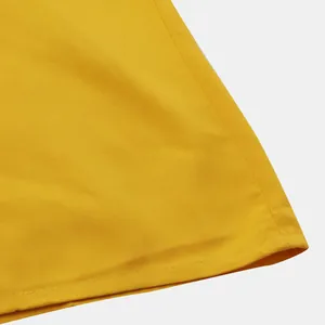 Detail shot of the hem stitching on a bright yellow men's casual short-sleeve shirt